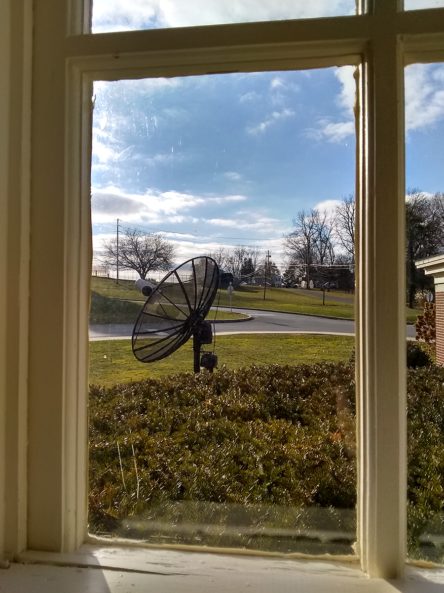 Satellite dish radio telescope viewed through window