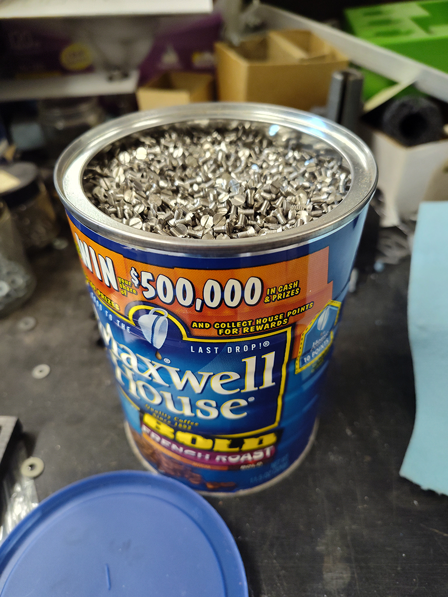 Coffee can filled to the brim with small screws