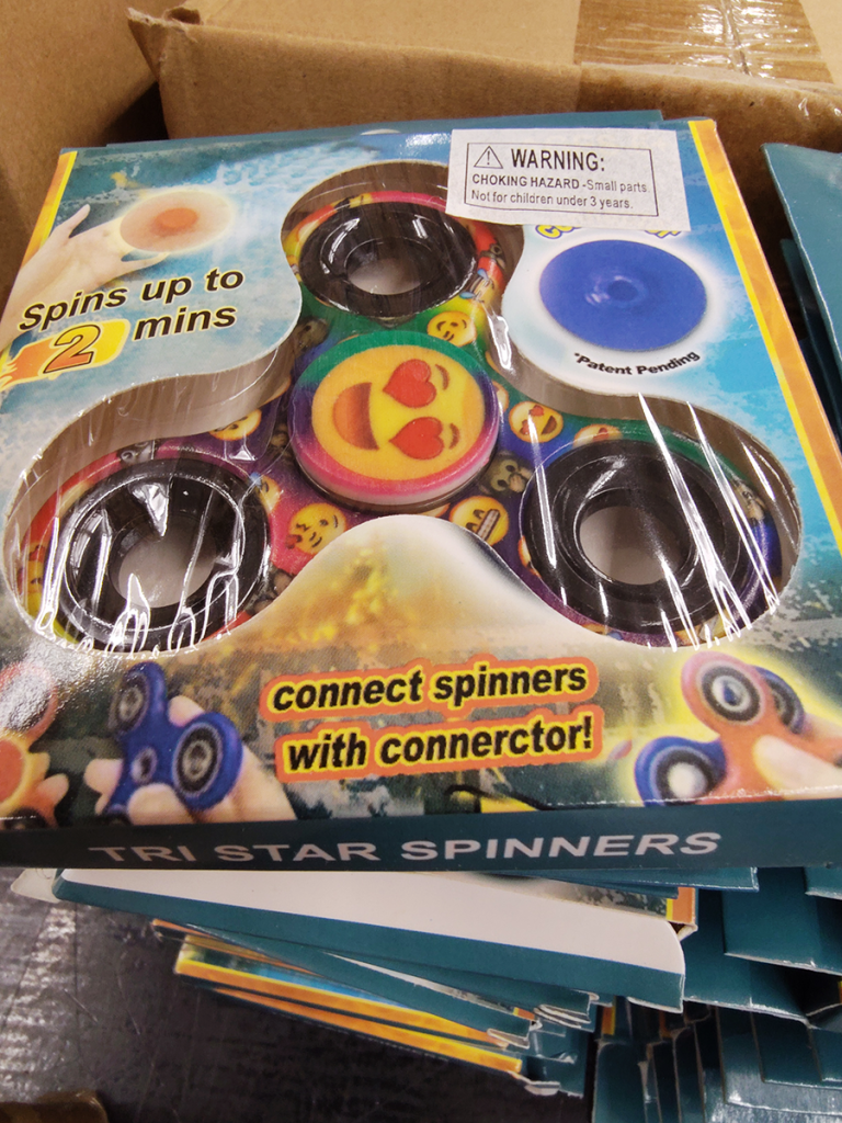 Fidget spinner in box reading "connect spinners with connerctor!"