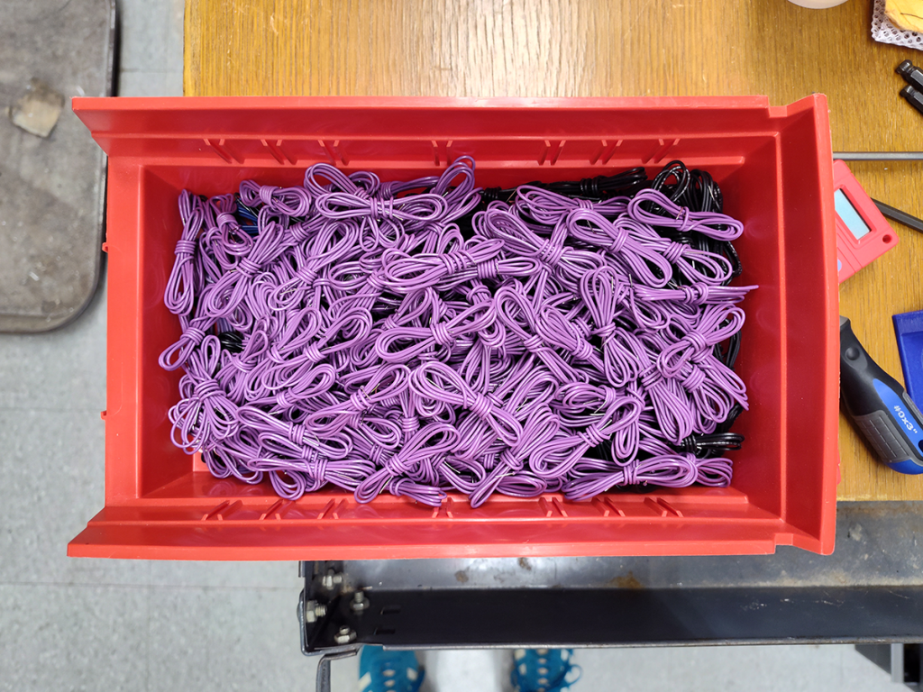 Red bin filled with twists of purple wire.