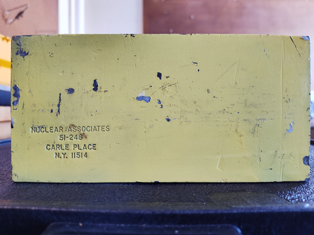 Lead brick, painted yellow, stamped by Nuclear Associates of Carle Place, NY.