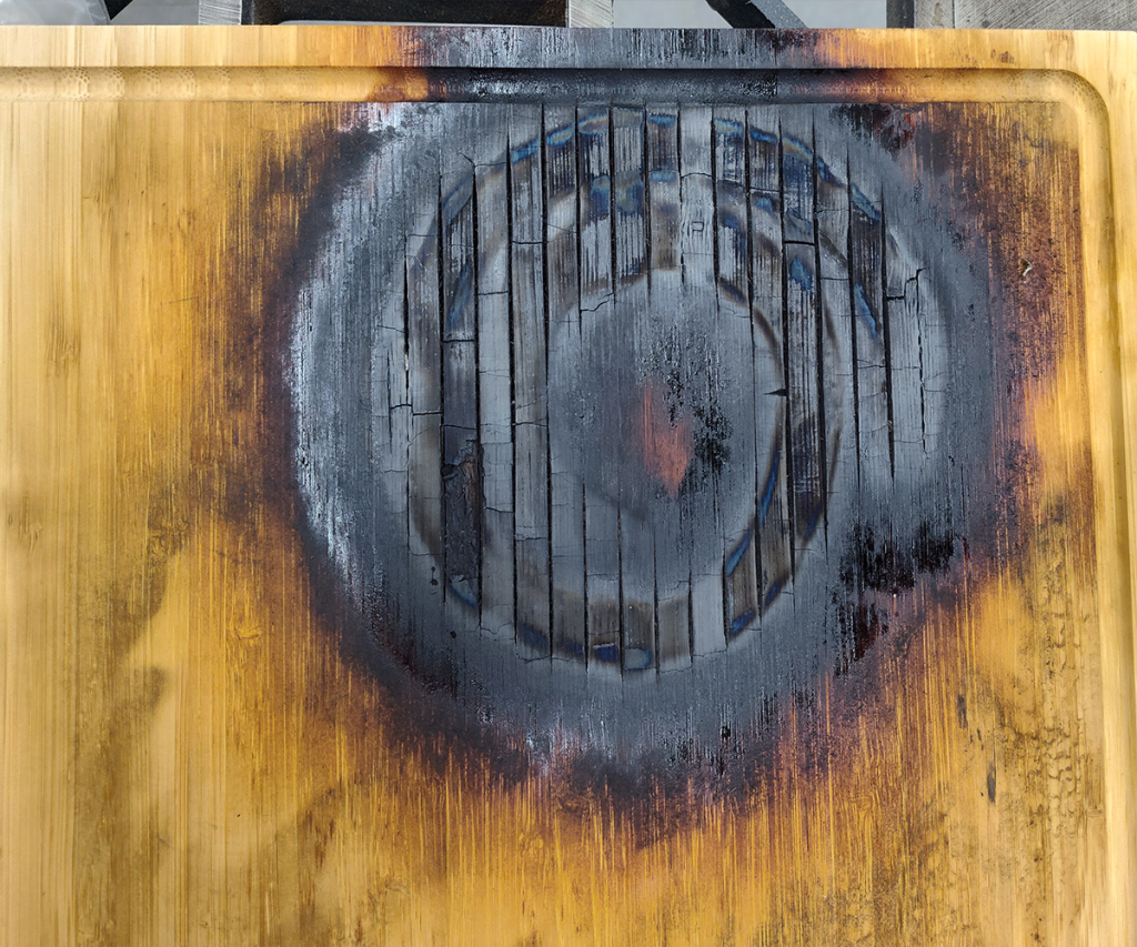 Bamboo cutting board with large spiral section burnt to charcoal