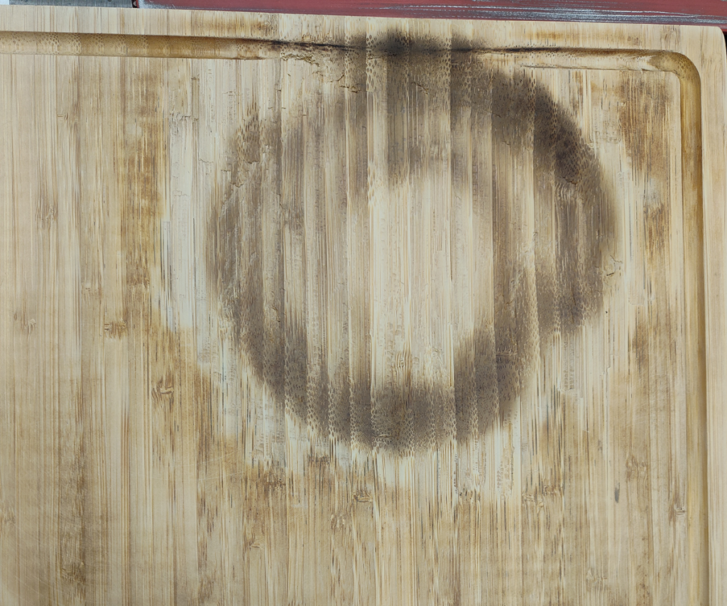 Bamboo cutting board with a smooth, round divot where the burnt area had been