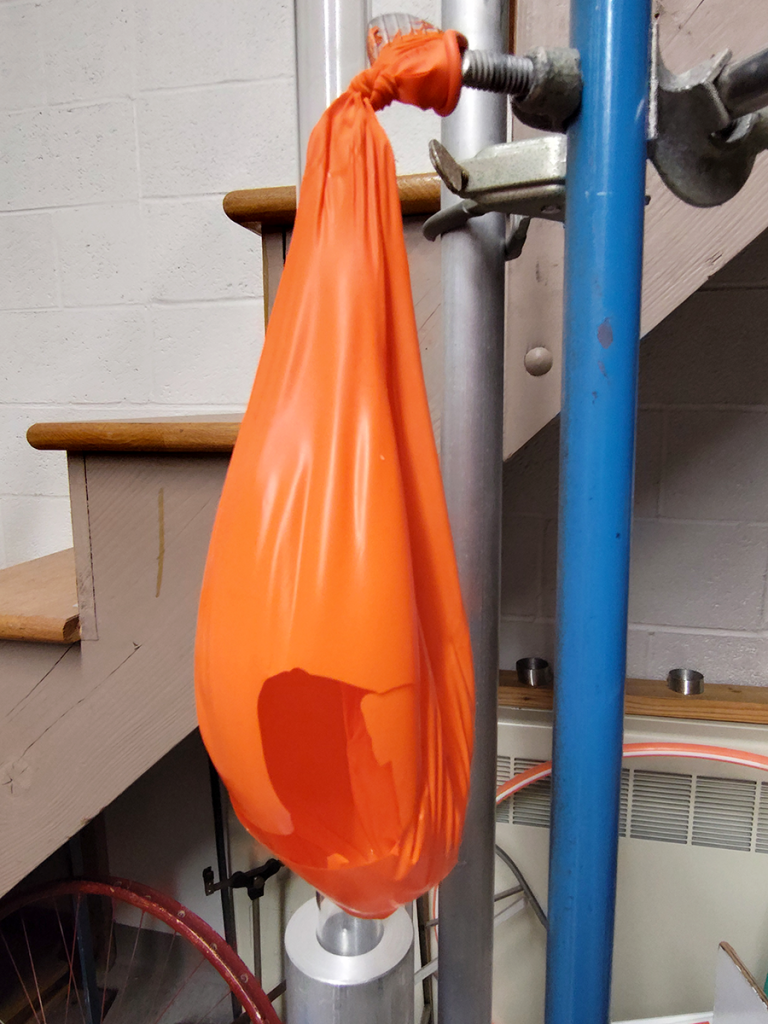 Rigid, old rubber balloon, cracked apart.