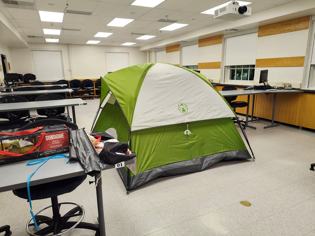 Large camping tent set up indoors.