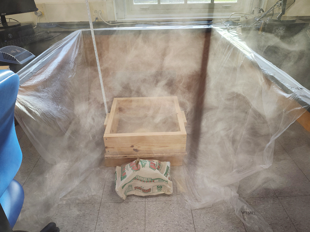 Dust cloud from pouring sand, illuminated by morning sunlight