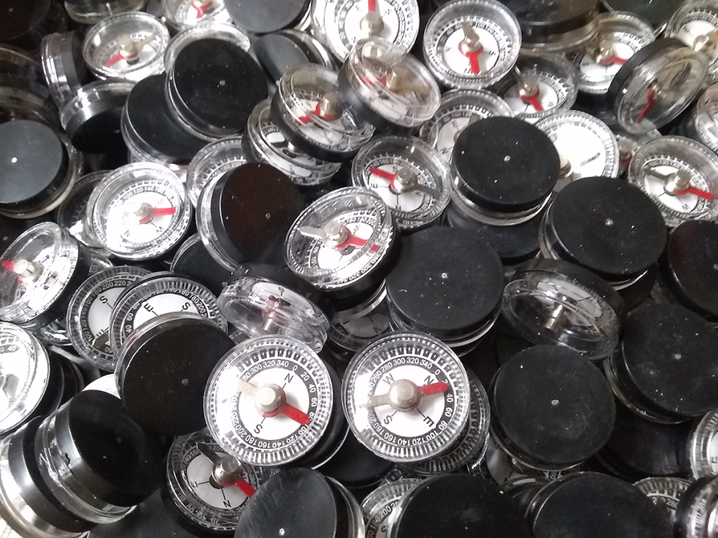 Pile of many, many small magnetic compasses.
