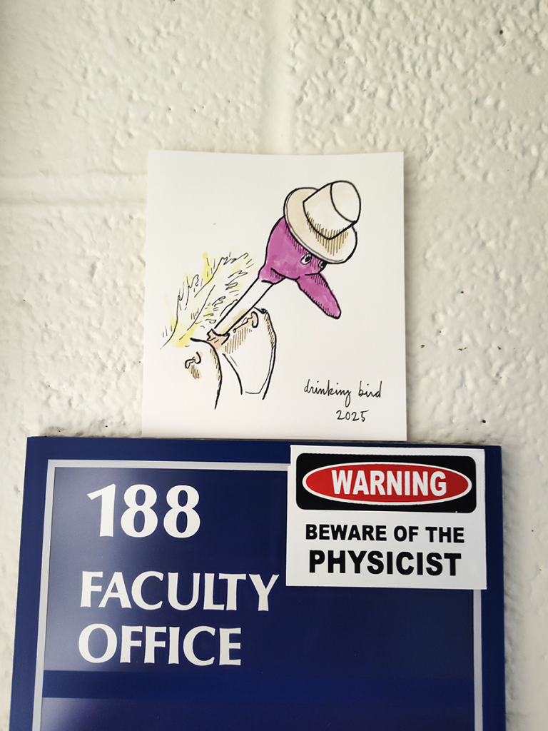 Sketch of a drinking bird on display above office sign.