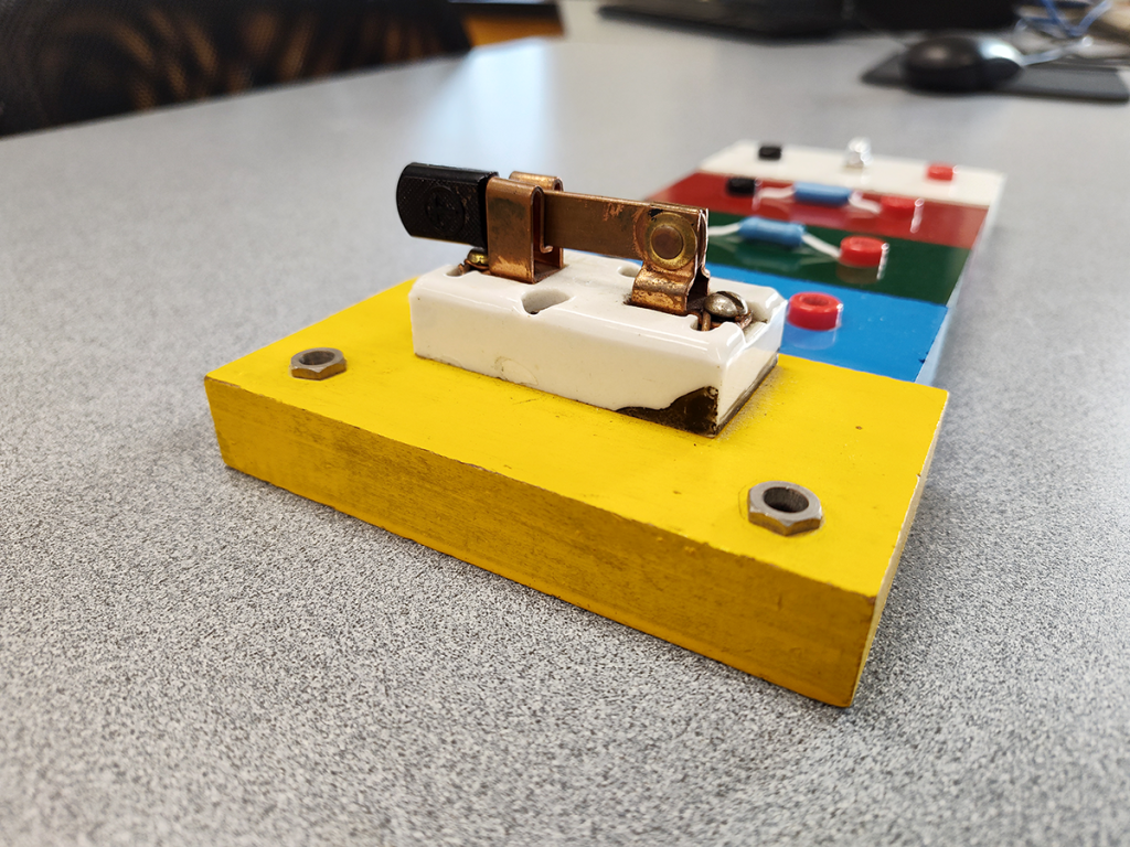 Mechanical knife switch and circuit-building lab components.